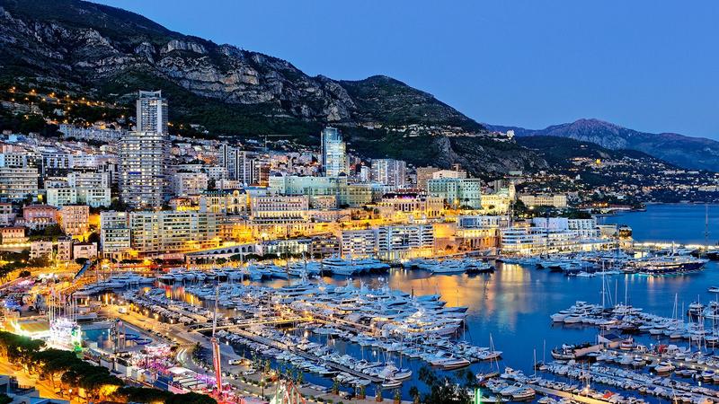 Europe's best travel escort destinations featuring Monaco harbour at night with Top Companions